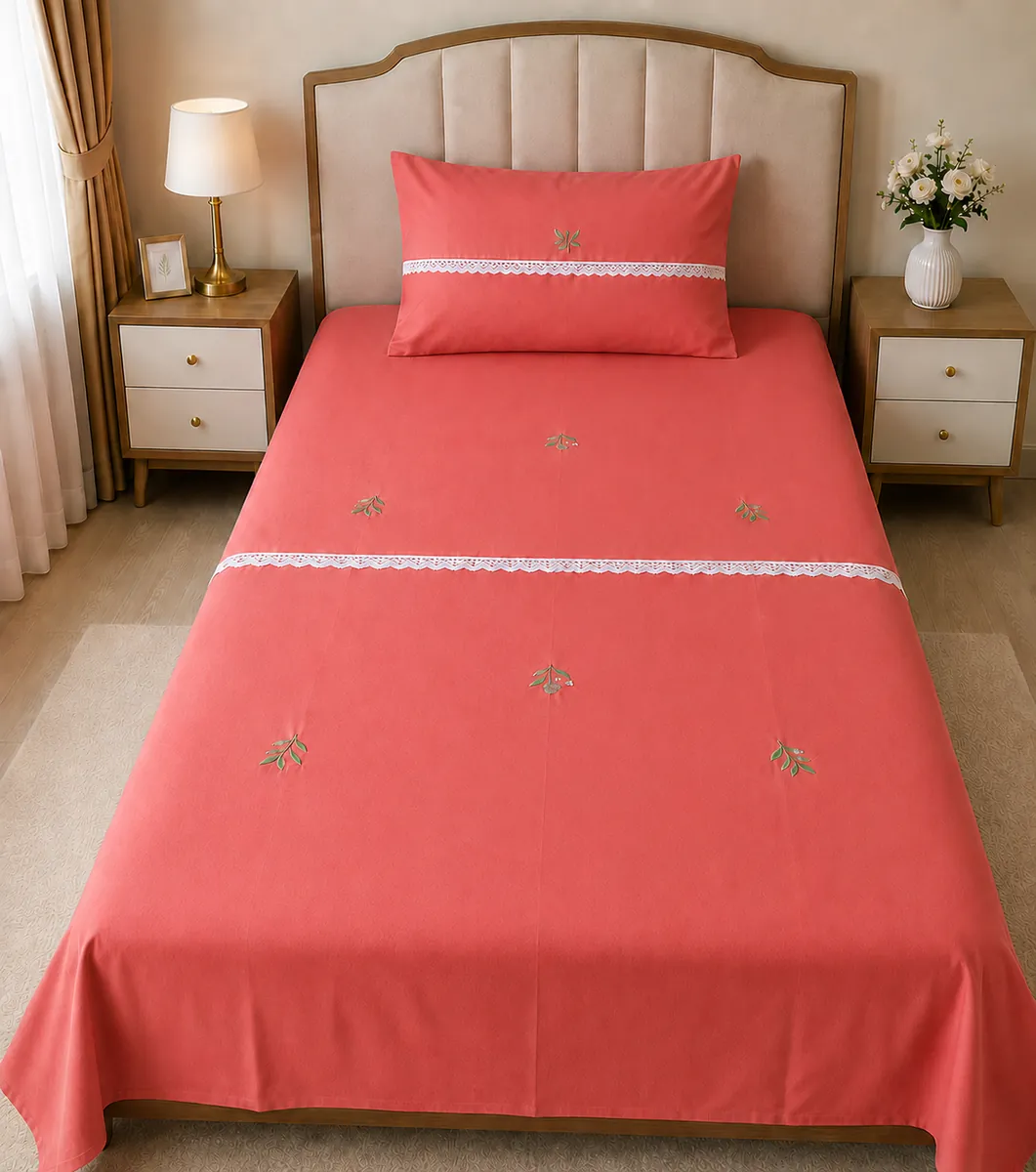 Bed sheets: A coral bed sheet with small green sprigs and white lace accents.