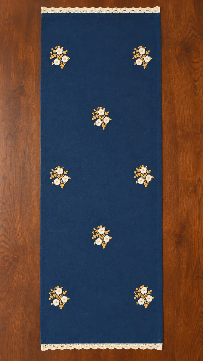 Table runners: Small white and gold floral clusters on a deep blue runner.